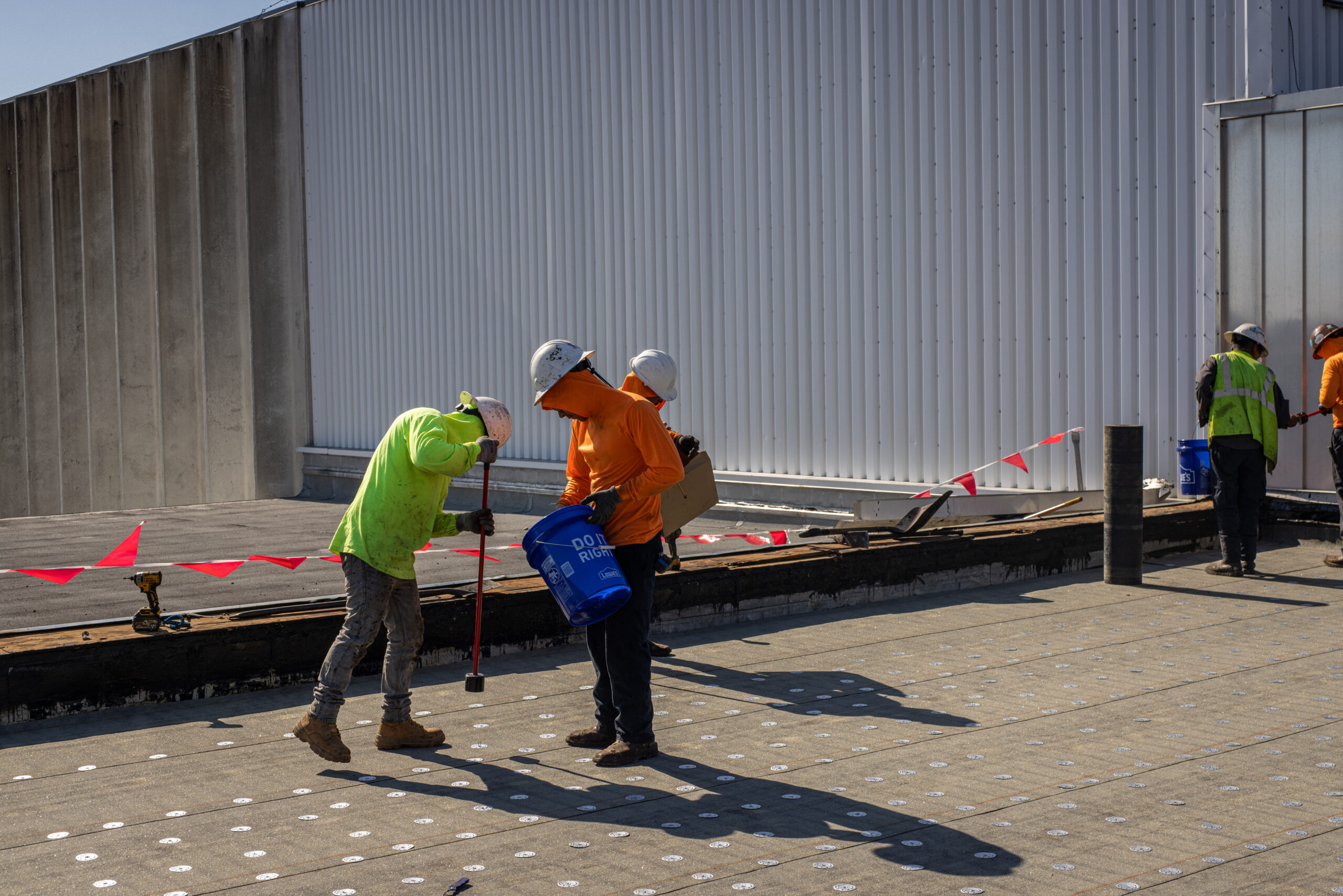 Workers from Eskola Commercial Roofing performing repair work on a rooftop.