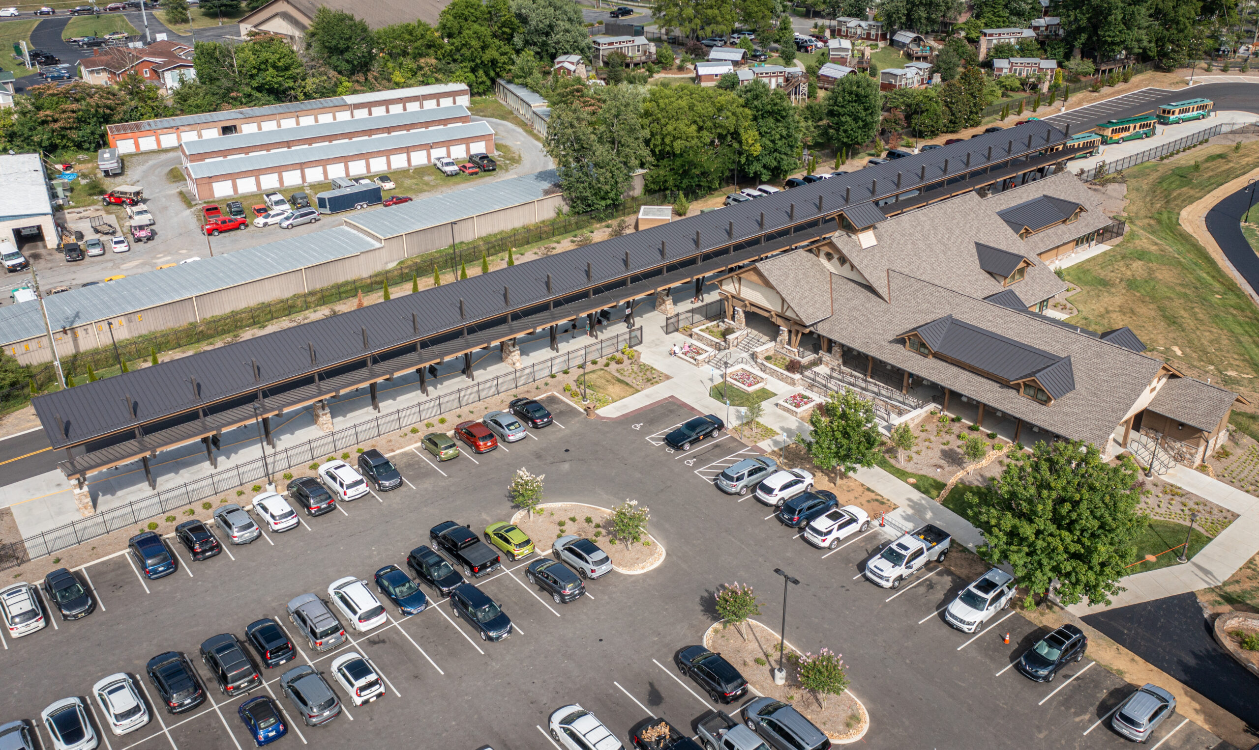 Aerial view of cars parked near a building with new roofing installed by Eskola Roofing, a local commercial roofing contractor.